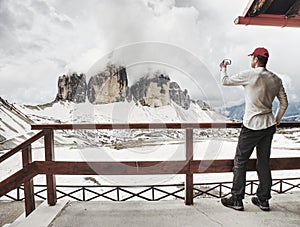 Hiker takes phone photo in mountains. Man on Alps