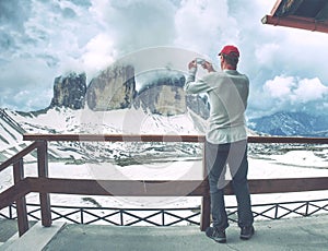 Hiker takes phone photo in mountains. Man on Alps photo