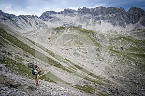 Hiker takes pictures on a mountain pass of the Allgau Alps