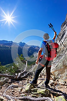 Hiker takes a rest observing a mountain panorama