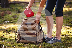 Hiker taking out first aid kit from backpack