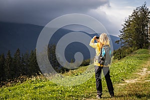 Hiker taking picture of landscape on her smartphone