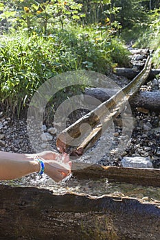 Hiker taking water from mountain stream