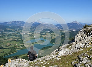 Hiker at the top of Mount Orkatzategi and Urkulu reservoir in the background, Euskadi