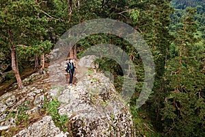 Hiker on top of mountain, woman take off backpack on the edge of the rock