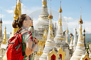 Hiker traveling with backpack and looks at Buddhist stupas. Bir