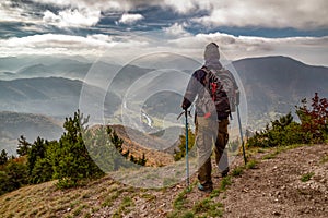 Turista s trekingovými palicami pri pohľade z vrcholu kopca Sip na Slovensku