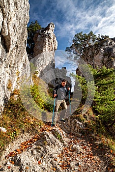 Turista s trekingovými palicami prechádzky medzi skalnými útvarmi na horskej ceste