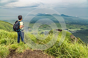 Hiker trekking to the hill top and watching mount Aso volcano