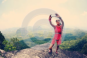 Hiker use smartphone taking self photo on seaside mountain top