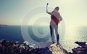 hiker using action camera mounted on selfiestick taking selfie