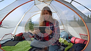 Hiker using digital tablet in mountains. woman having online video chat on pad