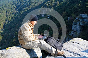 Hiker using a laptop outdoors