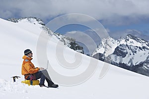 Hiker Using Laptop On Snowy Mountain Slope