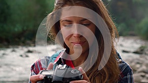 Hiker using photo camera during hike. Photographer looking pictures on camera