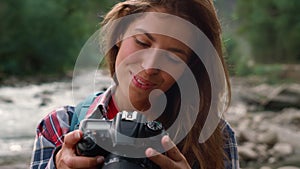 Hiker using photo camera during hike. Photographer looking pictures on camera