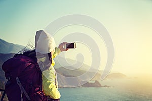 Hiker Using Smartphone taking photo at Seaside