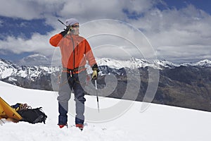 Hiker using walkie-talkie on snowy mountain peak