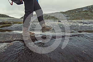 Hiker walking across shallow mountain river scenic photography