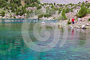 Hiker Walking on Footpath beside Shore Azure Mountain Lake