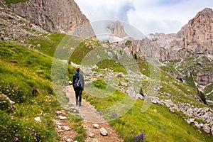 Hiker walking on mountain hiking trail in Dolomite alps