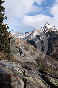 Hiker walking on the path in Pyrenees mountains near Gavarnie photo