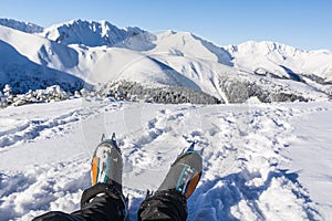 Hiker with warm mountaineering boots with automatic crampons in winter scenery in the mountains.