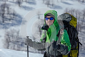 Hiker in winter mountains on sunny day