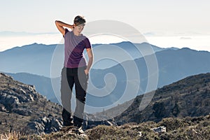 Hiker woman doing stretching on top of the mountain