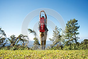 Hiker woman feeling victorious facing on the mountain