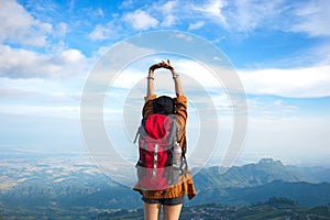 Hiker woman feeling victorious facing on the mountain,