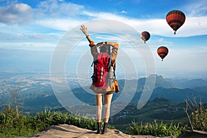 Hiker woman feeling victorious facing and seeing balloon