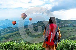 Hiker woman feeling victorious facing and seeing balloon