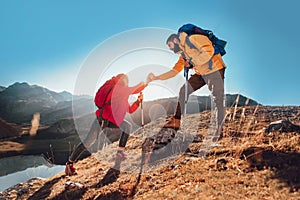 Hiker woman getting help on hike happy overcoming obstacle