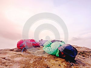 Hiker woman in hat lying on stone and relaxing in mountains