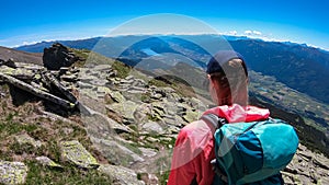 Hiker woman on idyllic hiking trail on alpine meadow with scenic view of lake Millstatt seen from mountain peak Boese Nase