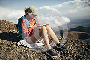 Hiker woman reading book on sloops of Mt Etna