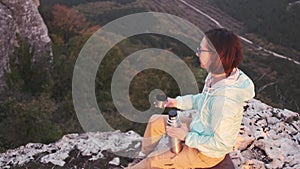 Hiker woman relaxing in mountains and drinking tea.