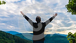 Hiker woman standing with hands up achieving the top