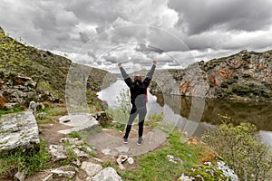 Hiker woman standing with hands up in The Arribes del Duero Natural Park. Spain