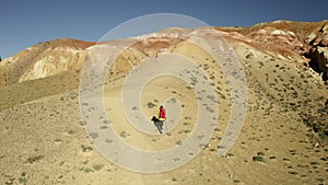 Hiker woman using hiking sticks to climb the hill. Aerial view of mountain. . Beautiful mountains landscape view. Drone