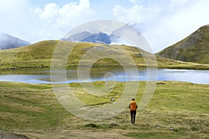 Hiker with yellow backpack in the Ibon de Escalar, Western Valleys Natural Park, Huesca Pyrenees