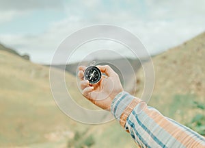 Woman searching direction with a compass in mountains, pov. photo