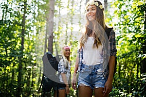 Hiker woman with backpack walking on path in summer forest