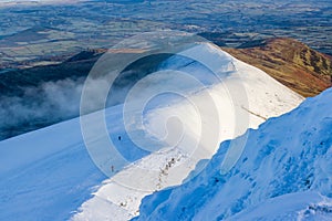 Hikers along a snow covered mountain ridge