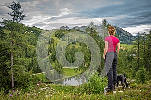 Hikers in the austrian alps walk on mountain hiking trails in the woods around the lakes