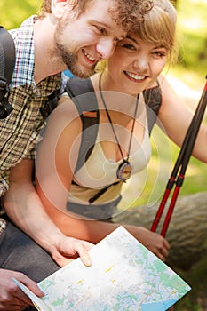 Hikers backpackers couple reading map on trip.