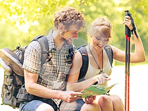 Hikers backpackers couple reading map on trip