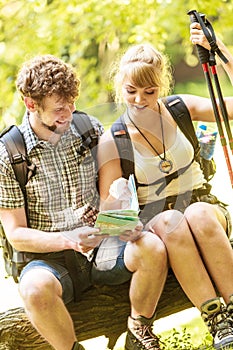 Hikers backpackers couple reading map on trip.