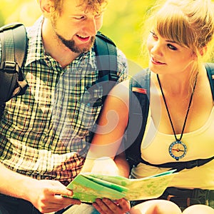 Hikers backpackers couple reading map on trip.